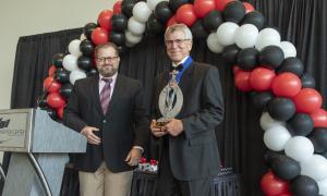 an award acceptance in front of balloons