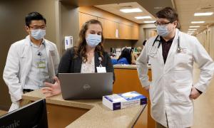 3 people looking at a laptop in the residency clinic