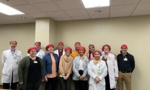 group of residents wearing red surgical caps