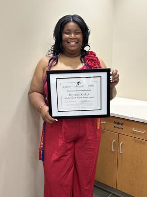 woman holds an award certificate